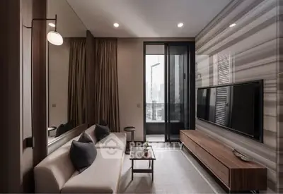 Modern living room with sleek furniture and large TV, featuring a stylish design and natural light.