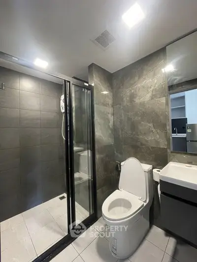 Modern bathroom with sleek shower and elegant fixtures in contemporary apartment.