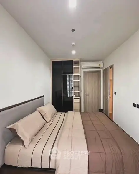 Modern bedroom with sleek design and ample storage in a contemporary apartment.