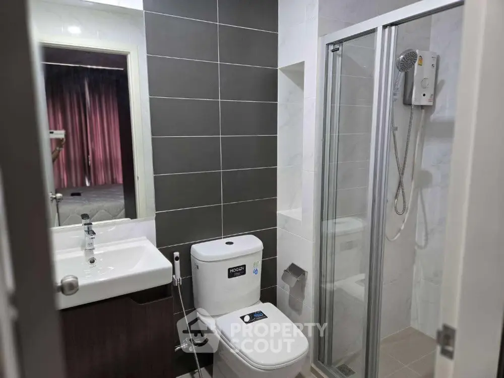 Modern bathroom with sleek design featuring glass shower and contemporary fixtures.