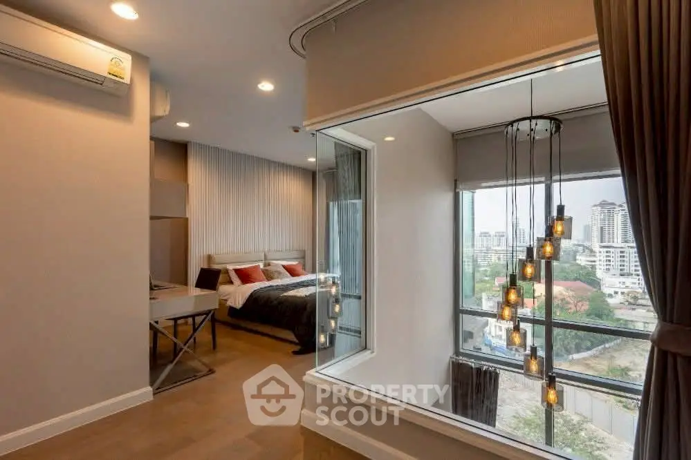 Modern bedroom with large window offering stunning city view