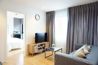 Modern living room with cozy sofa, TV, and natural light in stylish apartment.