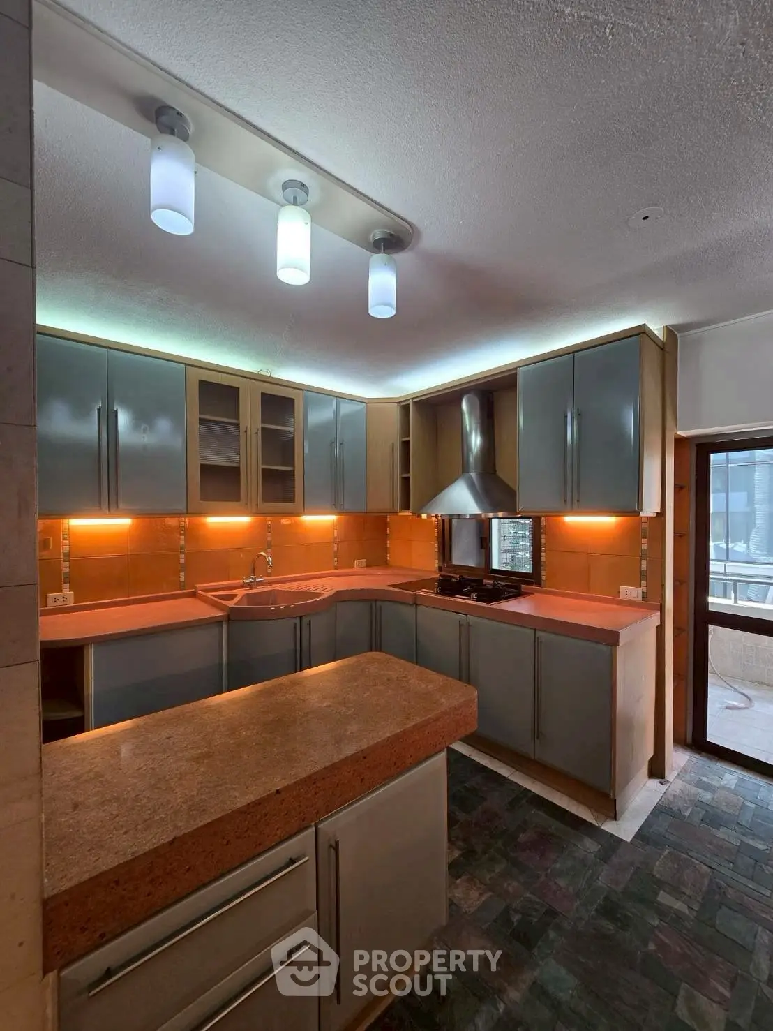 Modern kitchen with sleek cabinets and stylish lighting, featuring a gas stove and ample counter space.