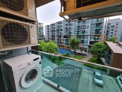 Modern apartment balcony with washing machine and pool view