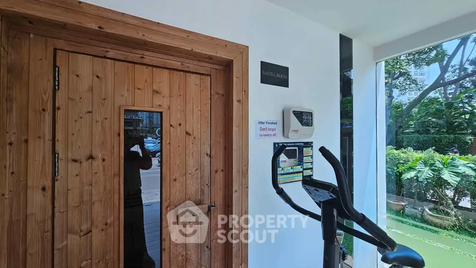 Modern sauna room entrance with exercise equipment and garden view