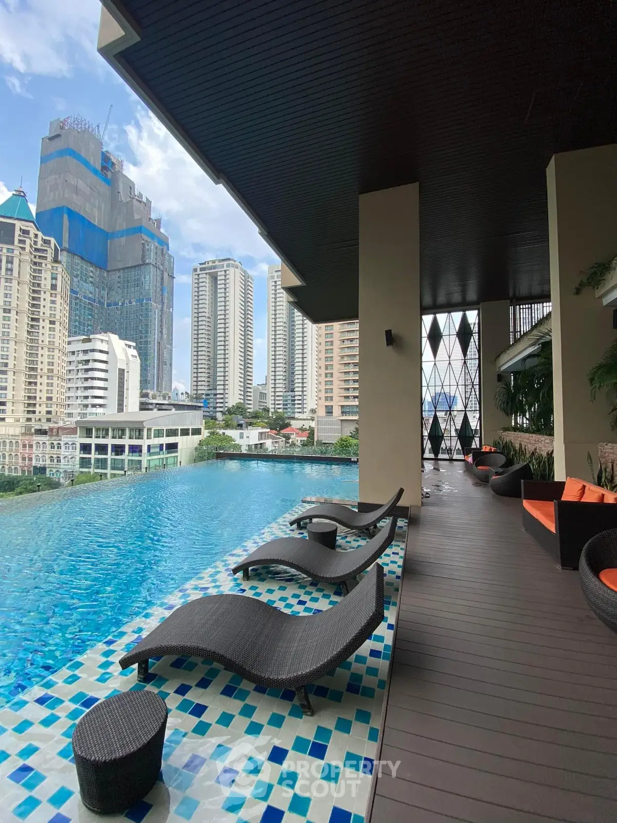 Luxurious rooftop pool with stunning city view and modern lounge chairs.
