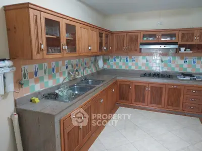 Spacious kitchen with wooden cabinets and tiled backsplash in modern home
