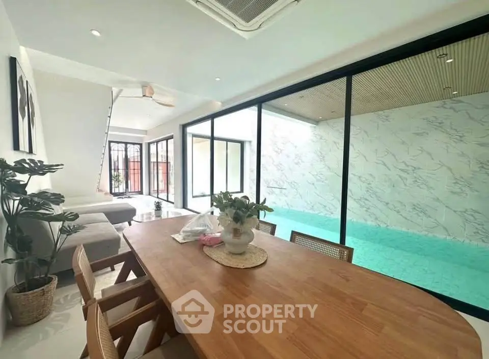 Luxurious open-plan living room with indoor pool and modern dining area, perfect for relaxation and entertainment.