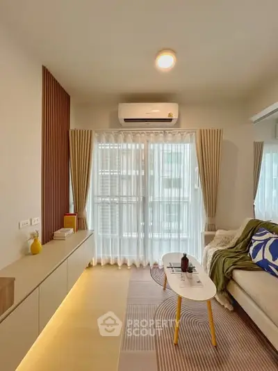 Modern living room with stylish decor and natural light, featuring a cozy sofa and elegant curtains.