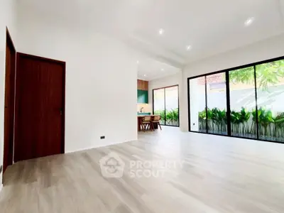 Spacious modern living room with large windows and garden view, perfect for natural light lovers.