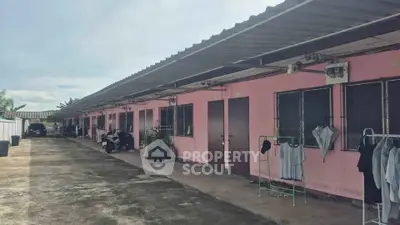 Charming row of pink exterior units with outdoor space, perfect for budget-friendly living.