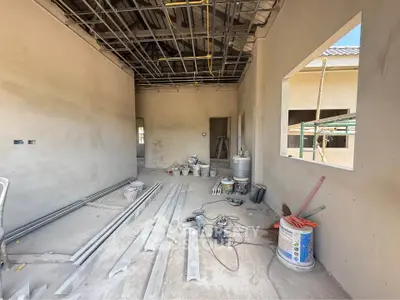 Spacious under-construction room with high ceilings and large windows, ideal for customization.