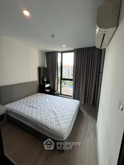 Modern bedroom with large window and air conditioning in a stylish apartment.
