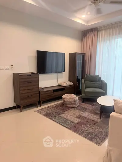 Stylish living room with modern furniture and large TV, perfect for relaxation and entertainment.