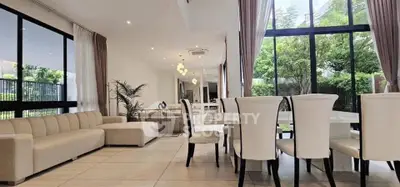 Luxurious open-plan living and dining area with garden view, featuring elegant furnishings and modern design.