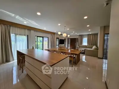 Spacious modern living room with open kitchen and elegant lighting