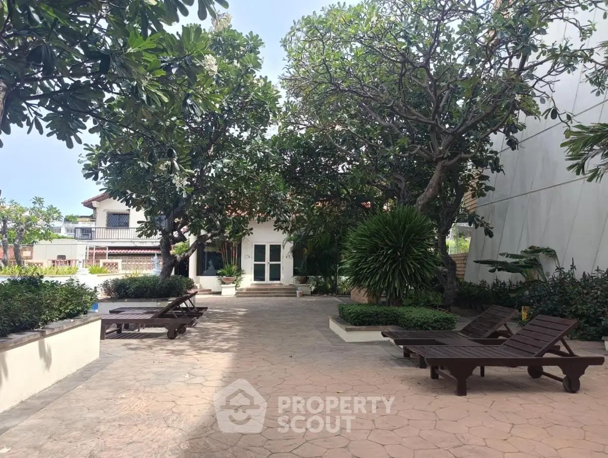 Serene garden area with lounge chairs and lush greenery, perfect for relaxation.