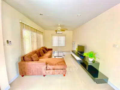 Spacious living room with modern decor and large sofa in bright natural light.