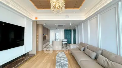 Luxurious living room with elegant chandelier and modern open kitchen layout