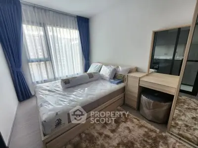 Modern bedroom with large window, stylish furniture, and cozy decor in a contemporary apartment.
