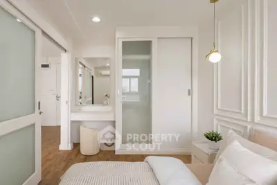 Elegant bedroom with modern decor, sliding closet doors, and a cozy vanity area.
