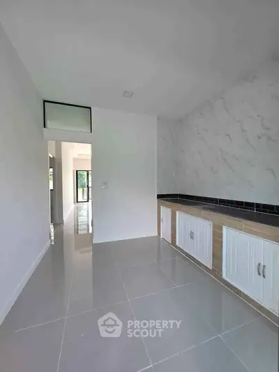 Modern kitchen with sleek cabinetry and marble backsplash in a bright, open space.