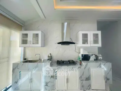 Modern kitchen with marble countertops and gas stove in sleek white design