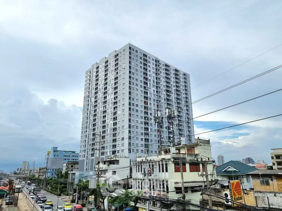 Modern high-rise building with urban surroundings and clear sky view.