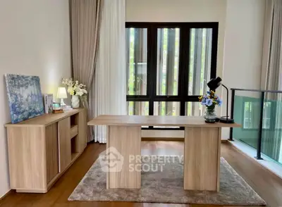 Elegant study room with wooden desk, large window, and stylish decor in modern home.