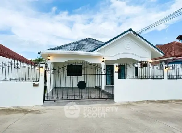 Charming single-story house with gated entrance and modern roof design.