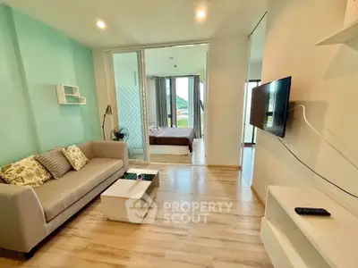 Modern living room with open layout and bedroom view, featuring stylish decor and natural light.