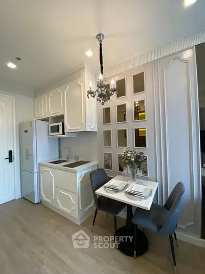 Chic modern kitchen with elegant dining setup and stylish chandelier.