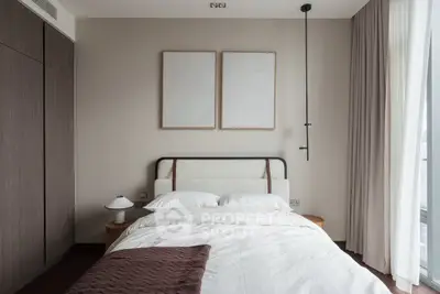 Elegant bedroom with modern decor, featuring a cozy bed, stylish lighting, and large windows for natural light.