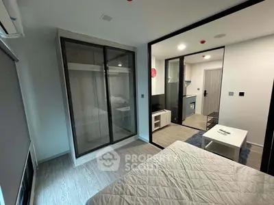 Modern studio apartment with sleek design and open layout, featuring a cozy bedroom and compact kitchen area.