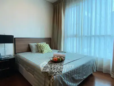 Cozy bedroom with large window and stylish decor in modern apartment