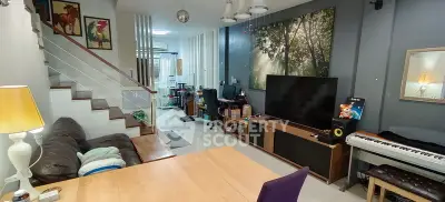 Spacious living room with modern decor and large TV, ideal for entertainment and relaxation.