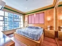 Luxurious bedroom with large windows and elegant wooden decor in a high-rise apartment.