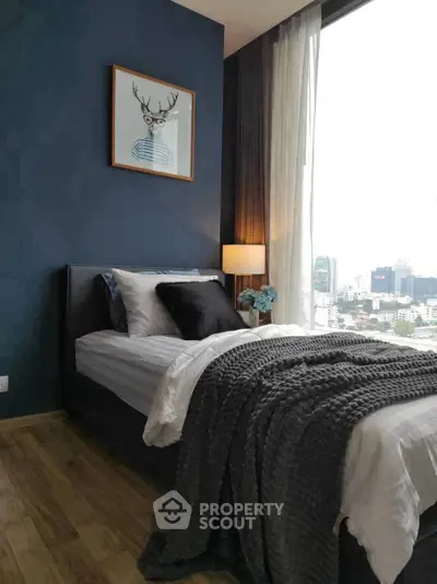Stylish bedroom with city view, featuring cozy bed and modern decor.