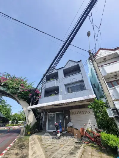 Charming multi-story building with street view and lush greenery