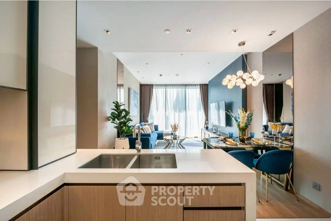 Luxurious open-plan kitchen and living room with modern decor and elegant lighting.