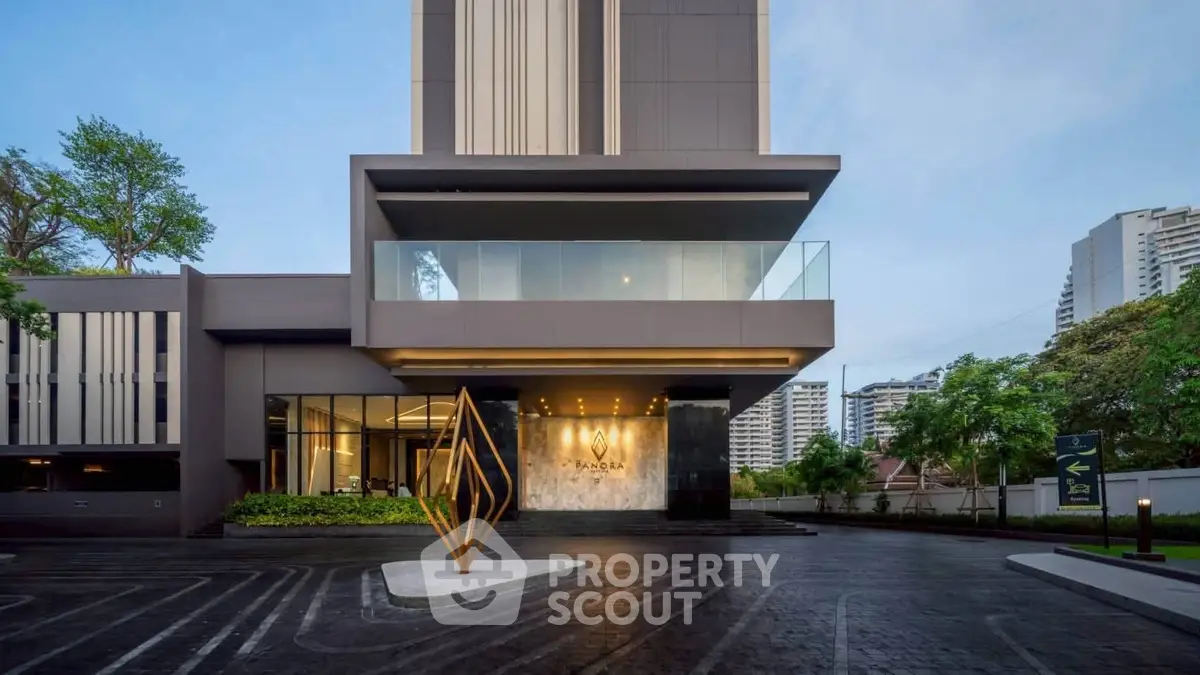Modern luxury building entrance with sleek design and spacious parking area, showcasing urban sophistication.