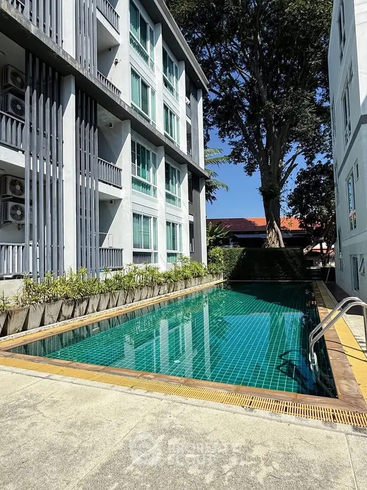 Modern apartment building with a serene outdoor pool and lush greenery.