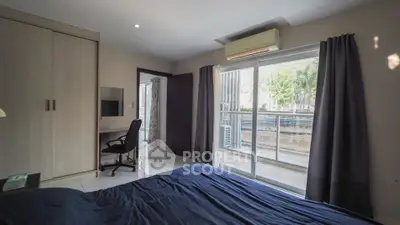 Spacious bedroom with balcony access and modern furnishings