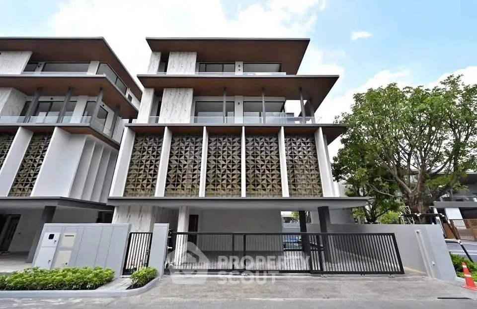 Modern multi-story building with unique facade and spacious parking area.