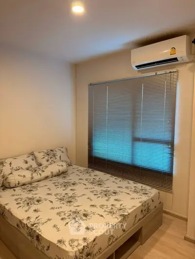 Cozy bedroom with floral bedding and air conditioning in modern apartment.