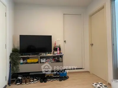 Modern living room with TV stand and shoe rack, showcasing minimalist design and organization.