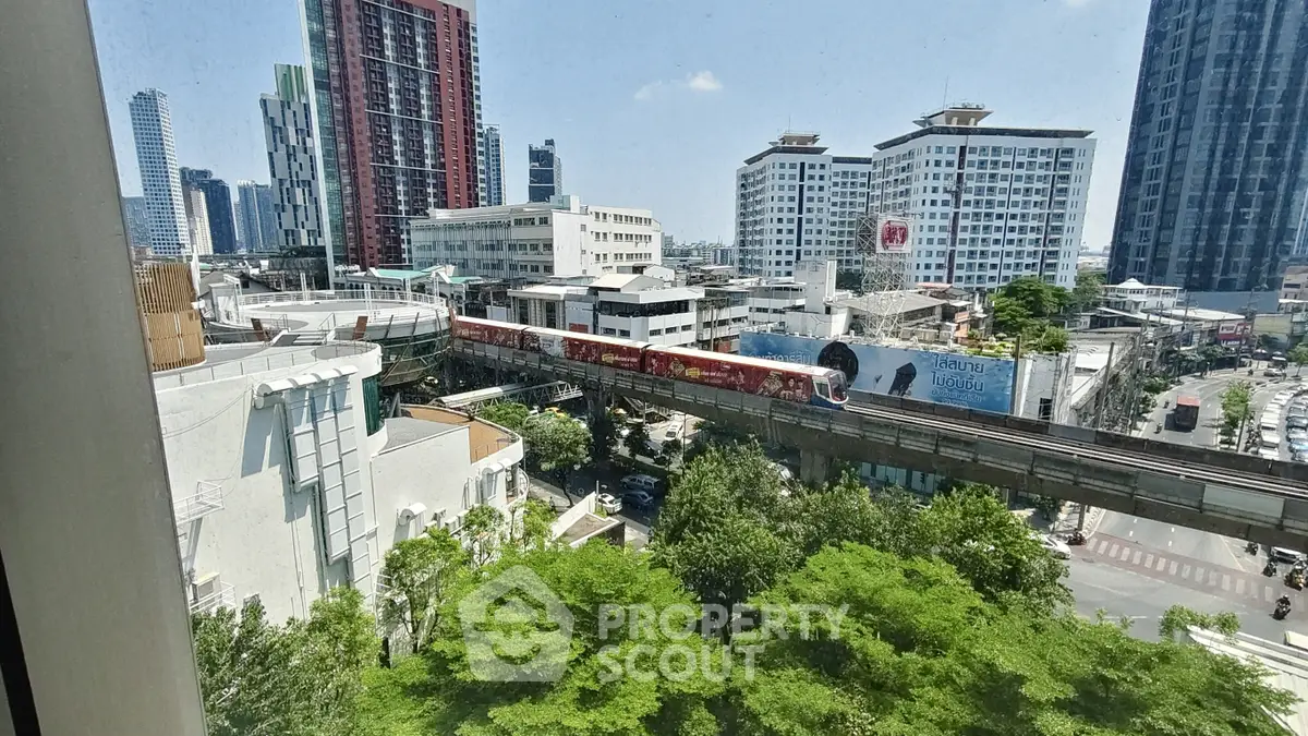 Stunning cityscape view from high-rise building with lush greenery and modern architecture.