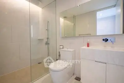 Modern bathroom with glass shower and sleek white fixtures