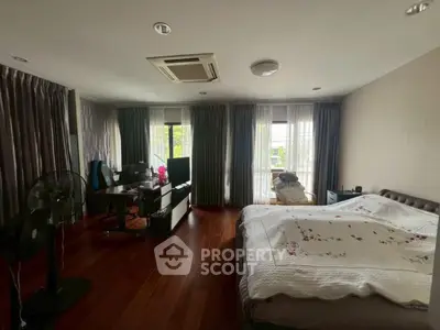 Spacious bedroom with elegant wooden flooring and natural light