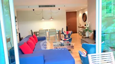 Spacious living room with modern decor and vibrant blue sofa, perfect for relaxation and entertaining.